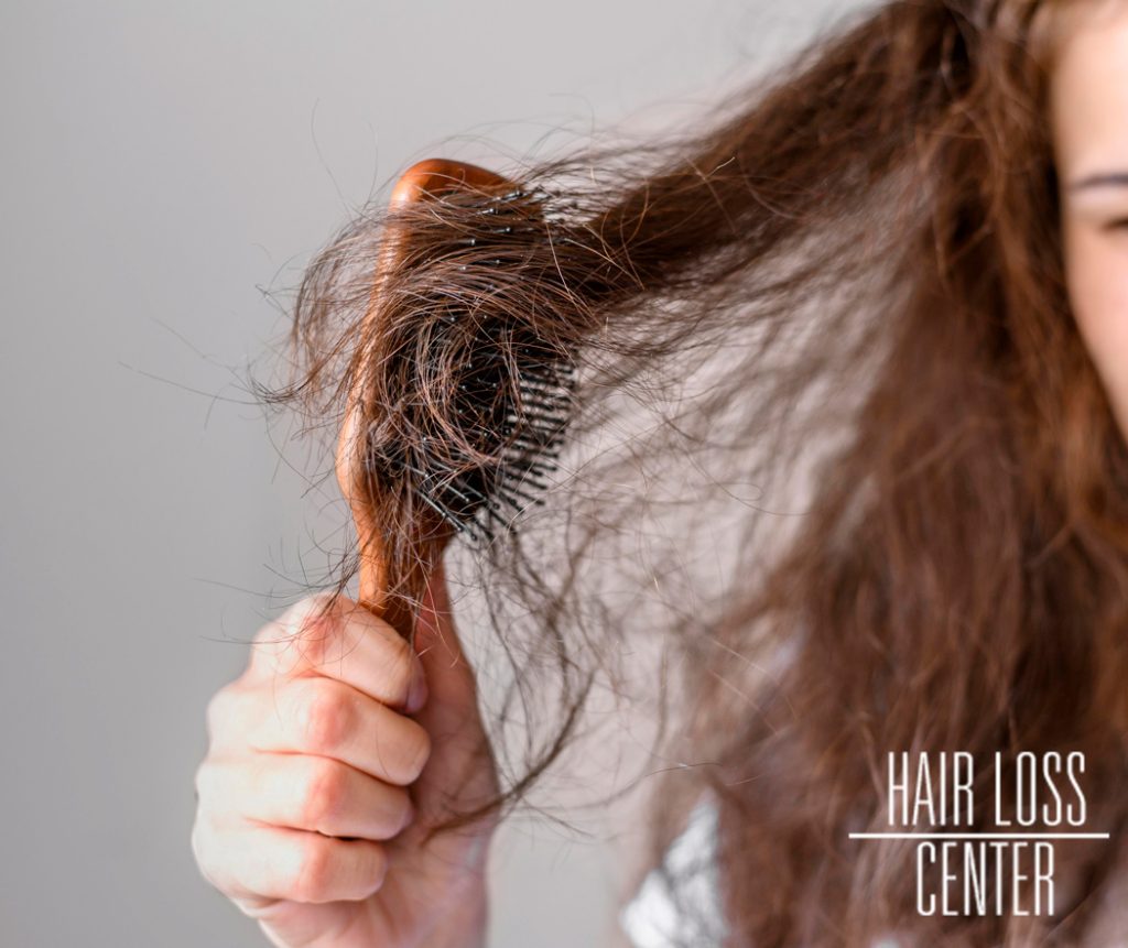 Woman struggling to brush dry hair